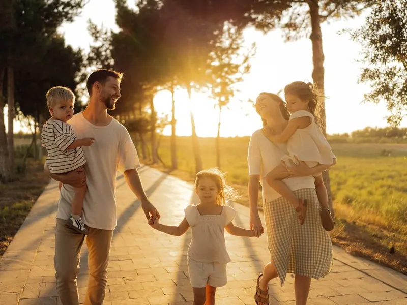 A young family walking together in late afternoon sunlight