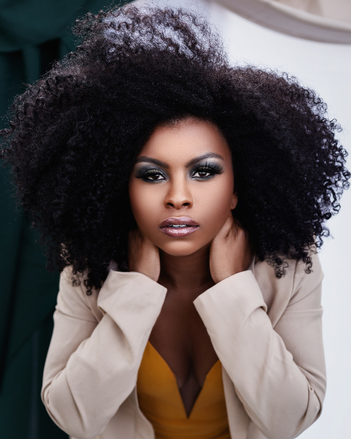 Woman in White Blazer With Black Curly Hair